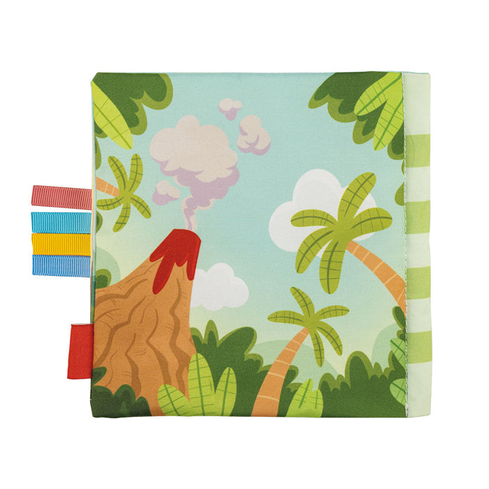 The Baby Sensory Book | Dino features a soft fabric cover with a volcano, red lava, palm trees, and green foliage under a blue sky. Colorful ribbon tags make it ideal for sensory play or tummy time.