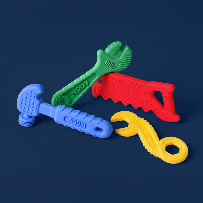 Four colorful plastic toy tools—a blue hammer, green wrench, red saw, and yellow spanner—from the Tool Teethers (4 Pack) are arranged on a solid dark blue background.
