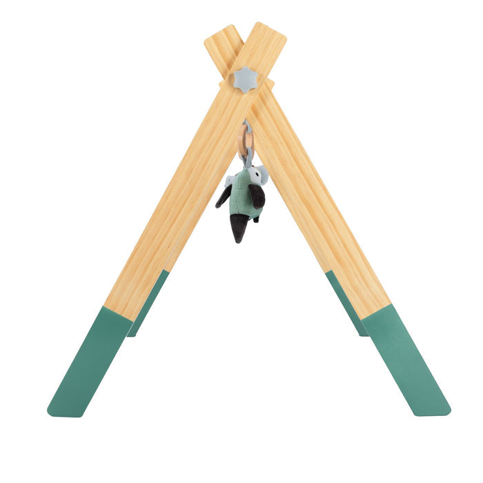 The Wooden Play Gym features green-tipped A-frame legs and hanging toys, with a small plush toy at the center.