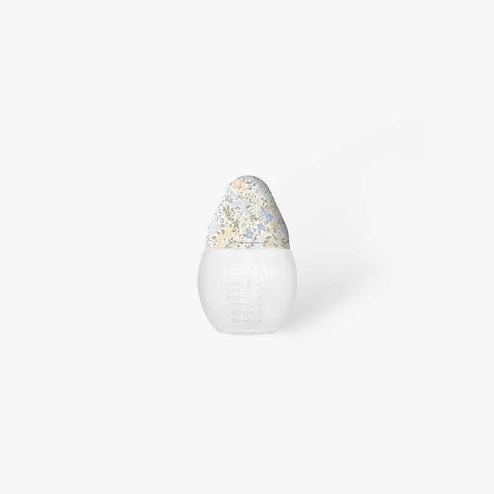 Baby bottle with a floral top on a white background
