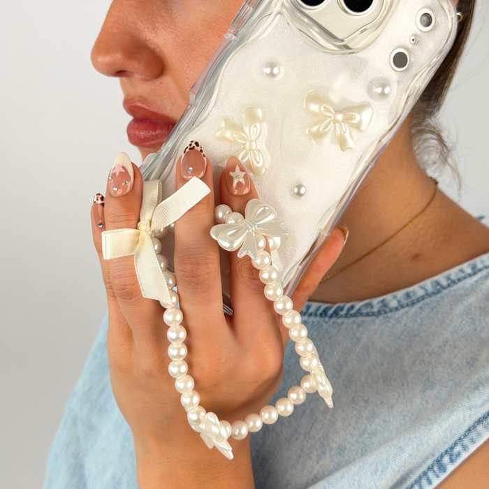 Girl on the phone holding her soft girl coquette phone strap