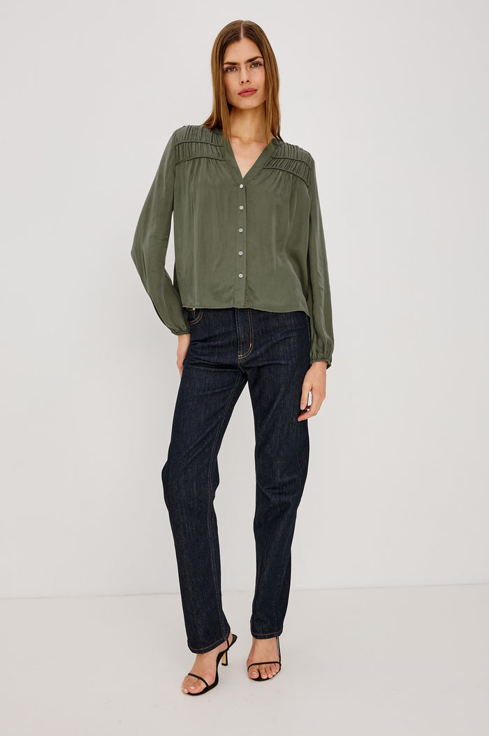 Cadence Shirt in Silky Fabric With Cutaway V-Neck, Shirred Yoke, Front Button Placket, and Slight Puff Long Sleeves and Elastic Cuffs in Washed Olive Colorway - Full Body Front View Featured on Model
