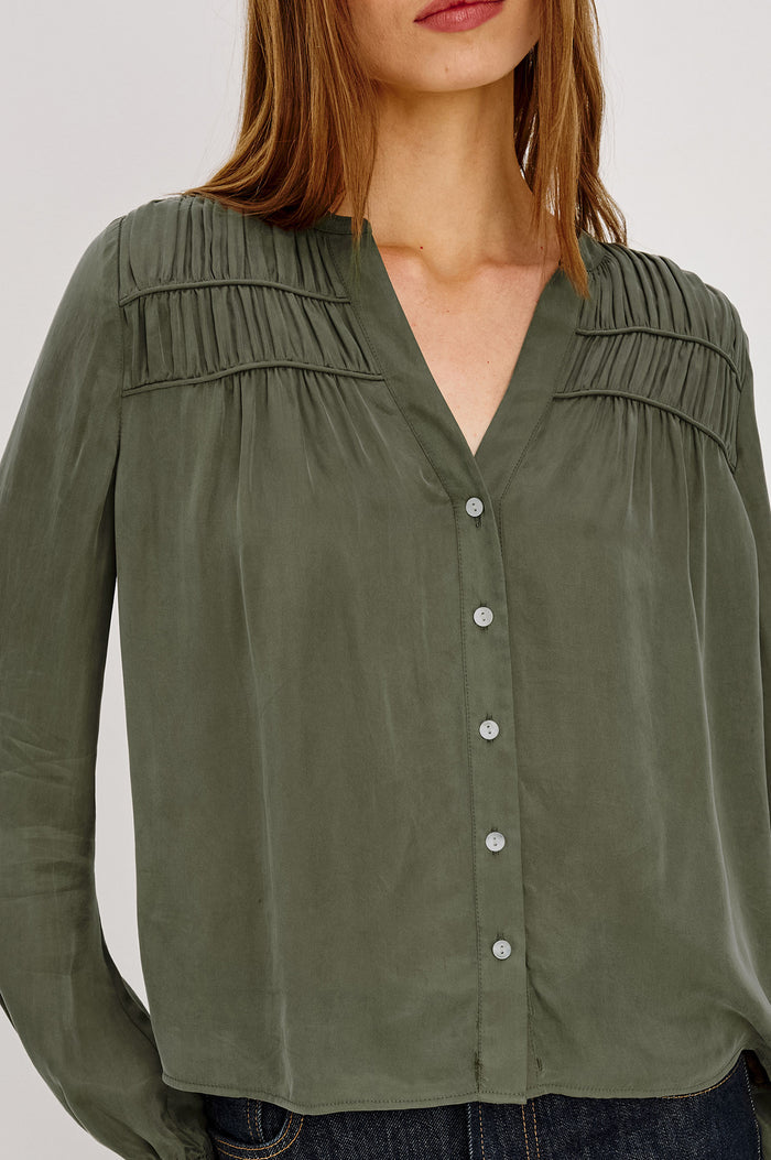 Cadence Shirt in Silky Fabric With Cutaway V-Neck, Shirred Yoke, Front Button Placket, and Slight Puff Long Sleeves and Elastic Cuffs in Washed Olive Colorway - Upper Body Front View Featured on Model