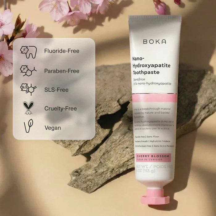Boka Nano-Hydroxyapatite Toothpaste with cherry blossom flavor on a beige background with floral elements.