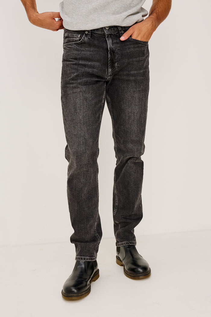 Clayton Slim Straight Jean With 5-Pocket Styling, Belt Loops, and Front Zip-Fly in Faded Onyx Colorway - Lower Body Front View Featured on Model