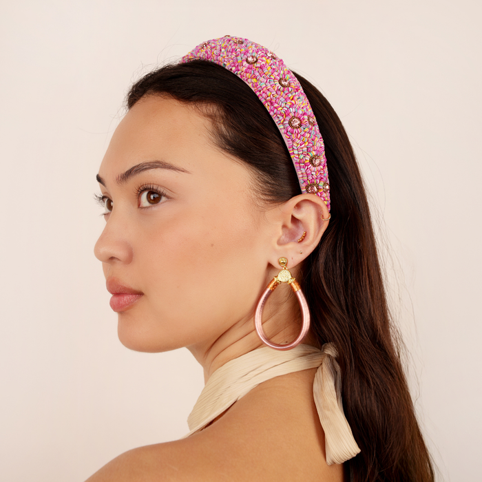 a woman with a headband and earrings