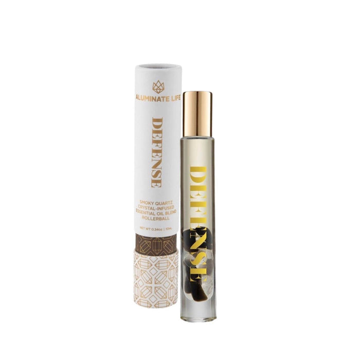 Defense RollerBall | Aluminate Life essential oil blend in a clear glass roller bottle with gold cap, next to its white and gold decorative packaging, promoting wellness and skincare.