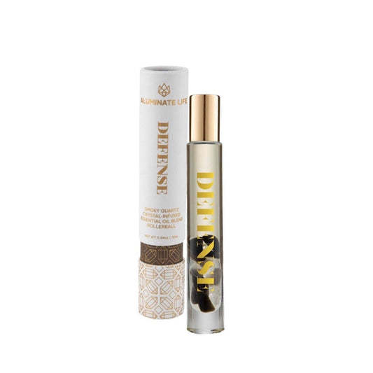 Defense RollerBall | Aluminate Life essential oil blend in a clear glass roller bottle with gold cap, next to its white and gold decorative packaging, promoting wellness and skincare.