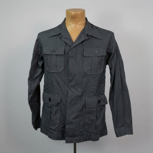 Dark gray jacket on a mannequin against a plain background
