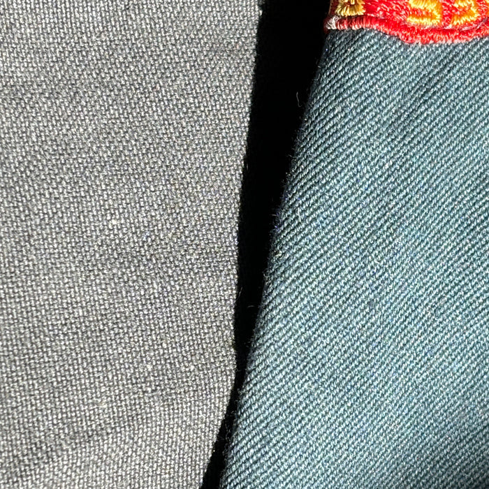 Close-up of gray fabric with a red and yellow logo on the corner.