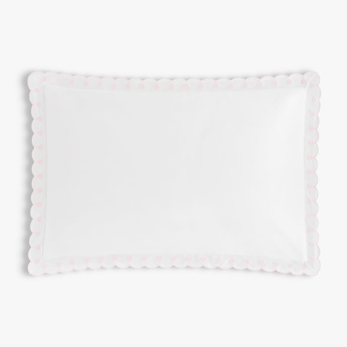 White pillow with scalloped edge on a light white background