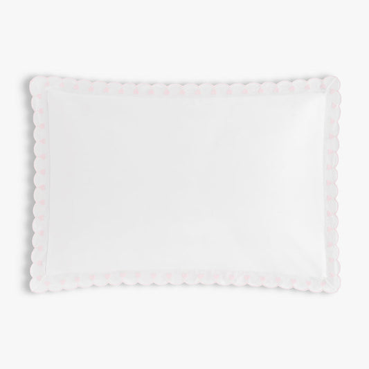 White pillow with scalloped edge on a light white background
