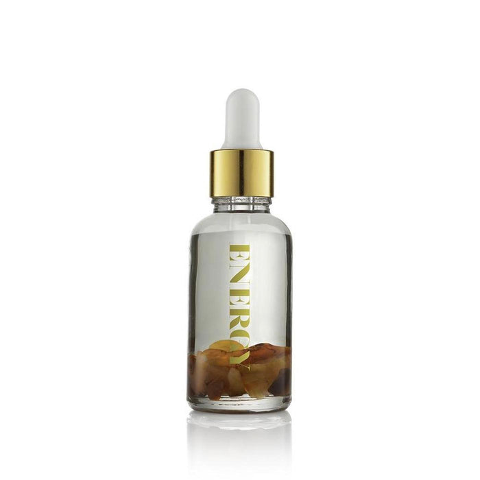 Clear glass vial with a gold dropper cap containing Energy Essential Oil Vial | Aluminate Life, featuring suspended natural botanical elements inside for wellness and body care use.