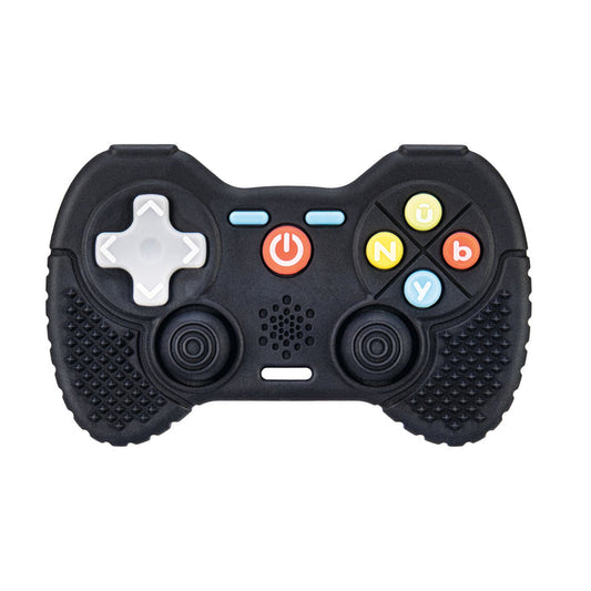 The Game Controller Teether is a playful baby teething toy inspired by classic video game controllers, featuring a black design with textured grips, a white D-pad, two joysticks, colored buttons labeled Y, B, n, and ü, plus a red power button in the center. Crafted from silicone for safe teething relief.