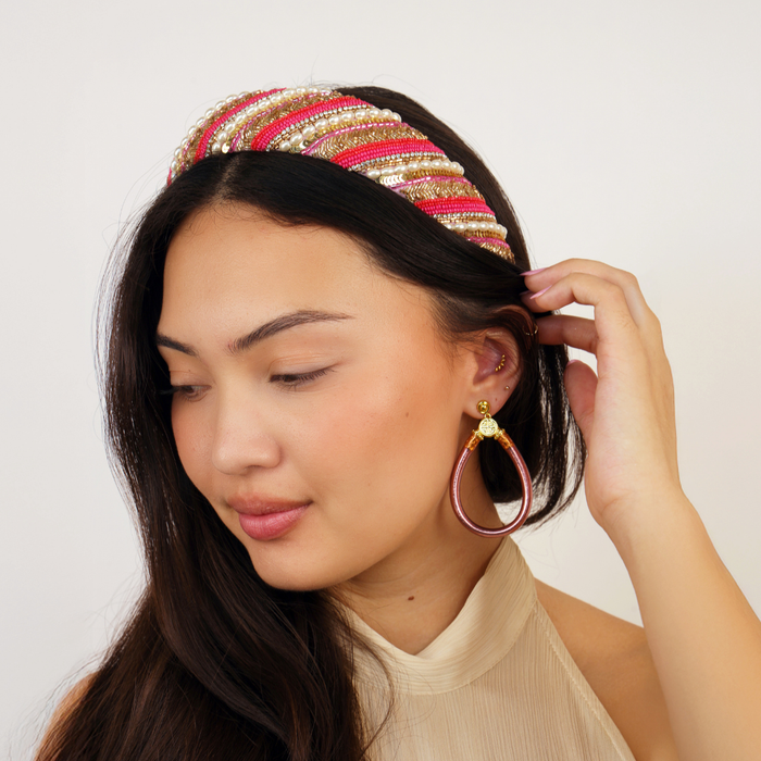 a woman with a headband and earrings