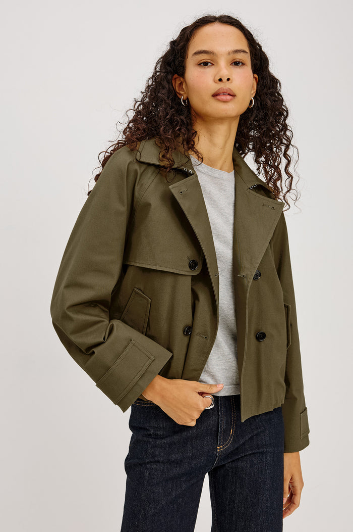 Jett Cropped Trench Jacket in Cotton Garbardine With Double-Breasted Design, Structured Collar, Pockets, and Long Cuffed Sleeves in Olive Colorway - Upper Body Front View Featured on Model