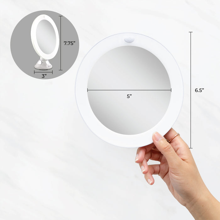 Zadro LEDPSC110 705004420884 environment photo user adjusting mount angle with dimensions, lighted wall mounted makeup mirror with magnification & suction cup in front of a real life setting