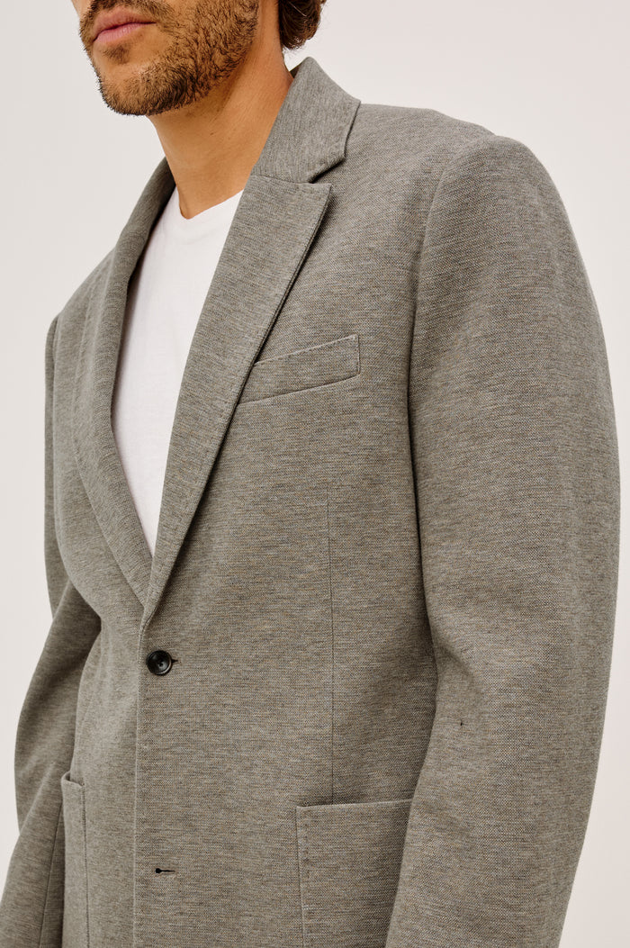 Lorenz Blazer in Ponte Jersey With Single-Breasted Design, Relaxed Fit, Jersey Lining, Notched Lapels, Chest Welt Pocket, Side Patch Pockets, Button-Cuff Long Sleeves, and Double Back Vents in Walnut Heather Colorway - Upper Body Front View Featured on Model
