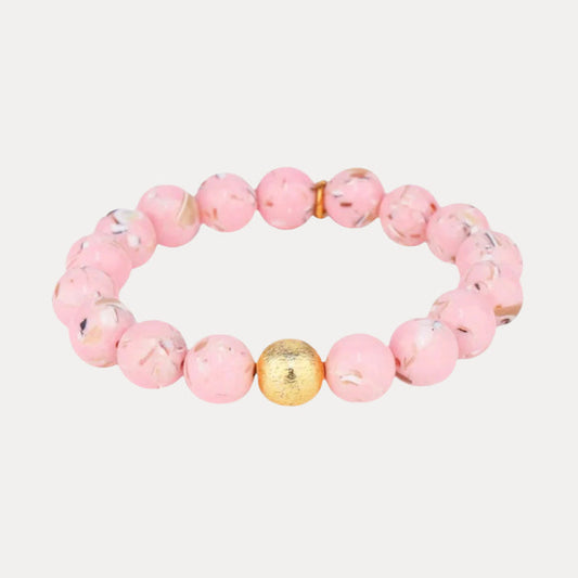 a pink beaded bracelet with a gold bead