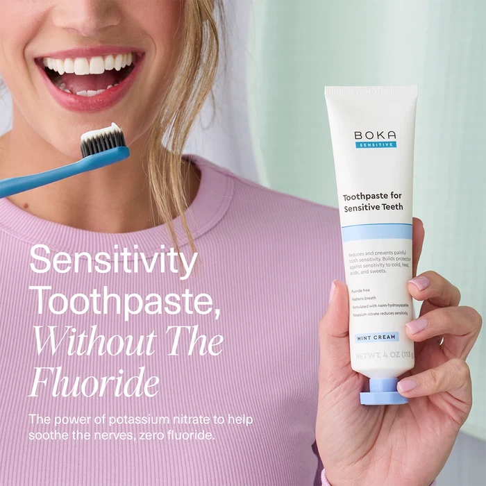 Person holding a tube of Boka toothpaste for sensitive teeth with text about sensitivity toothpaste without fluoride.