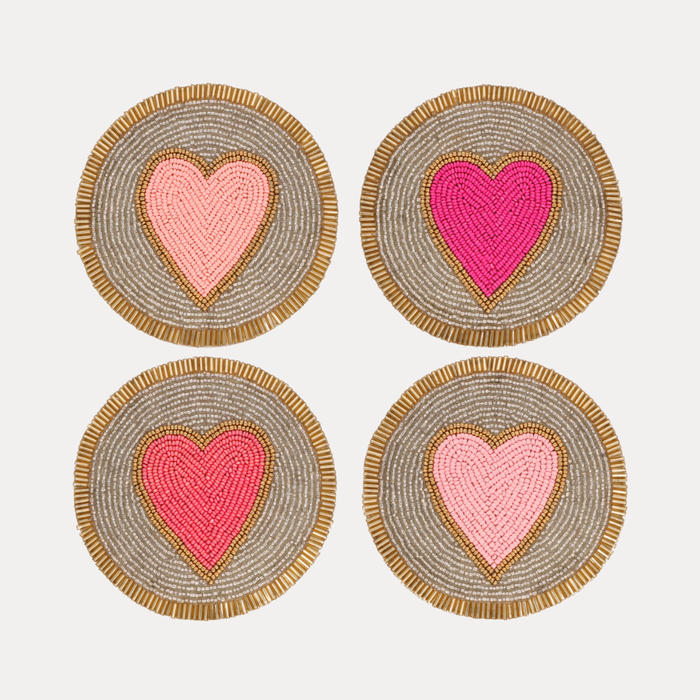 a set of coasters with pink and gold hearts
