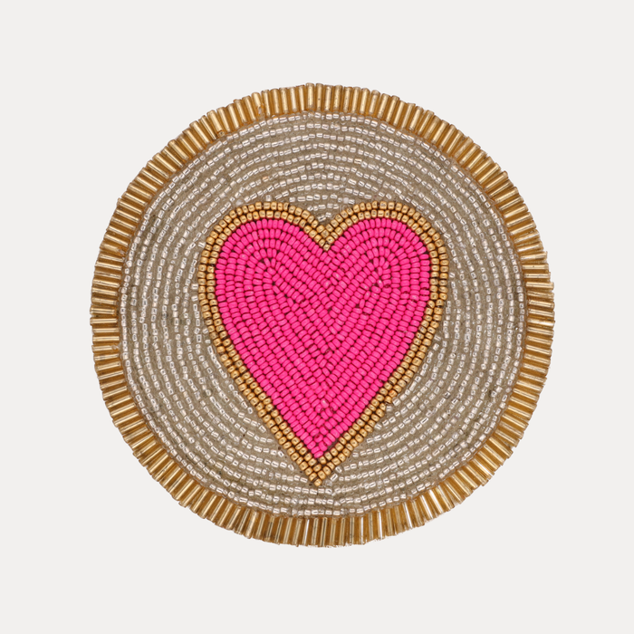 a pink heart on a gold and silver circle