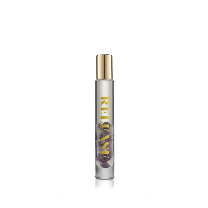 Clear glass rollerball bottle with small purple stones inside and gold cap, labeled Release Essential Oil Rollerball | Aluminate Life, designed for wellness and body care.