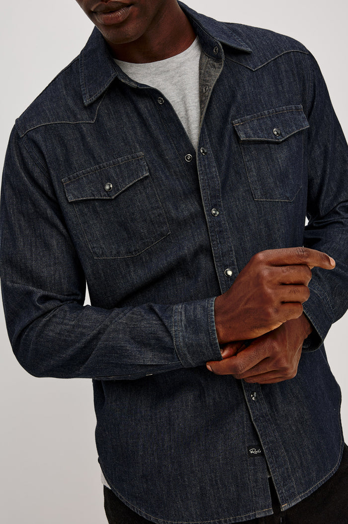 Roy Shirt in Rigid Rinsed Denim With Western Shoulder and Back Yokes, Spread Collar, Snap Front, Dual Chest Flap Pockets, and Shirttail Hem in Twilight Wash Colorway - Upper Body Front View Featured on Model