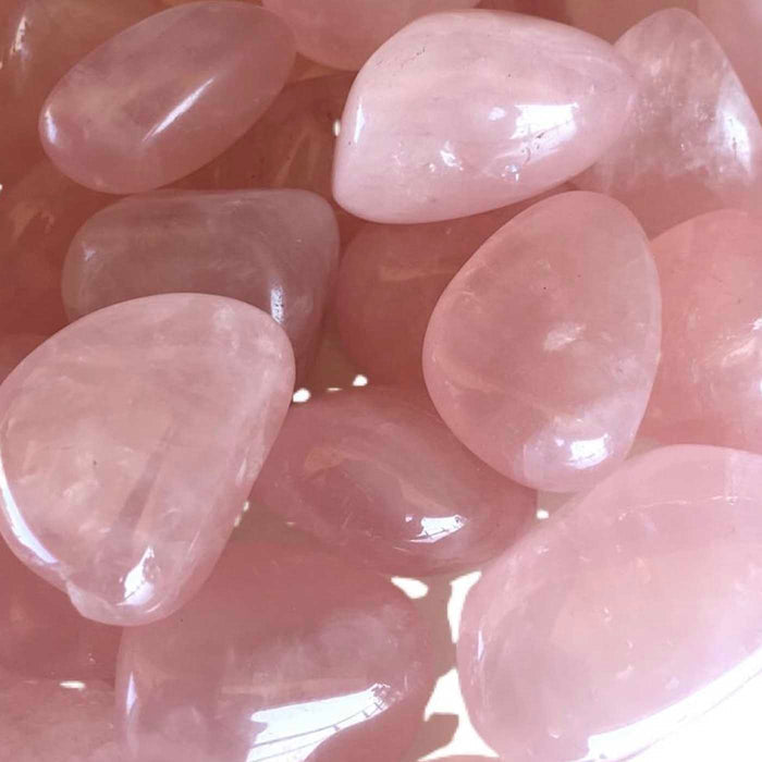 Close-up of polished rose quartz stones highlighting their smooth texture and soft pink color, associated with wellness and relaxation, for Sleep Candle Tin | Aluminate Life.