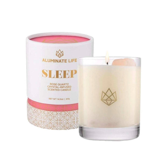 Sleep Glass Candle | Aluminate Life featuring a lit candle in a clear glass with a rose quartz crystal inside, alongside elegant packaging promoting relaxation and wellness.