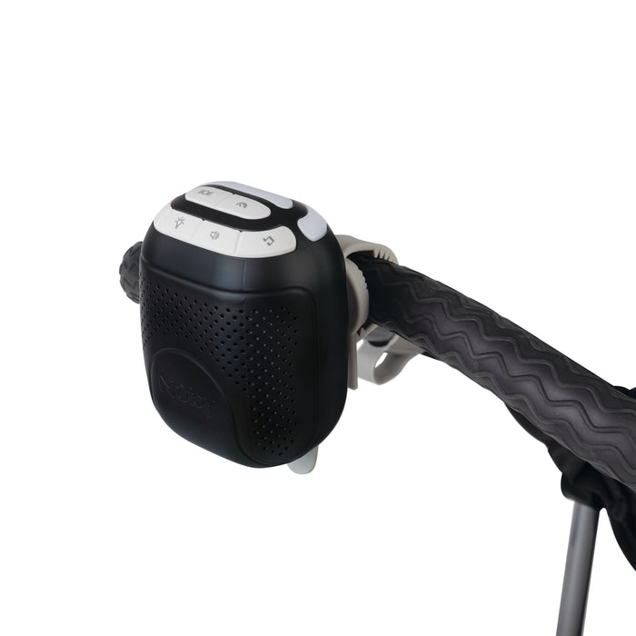 A close-up of the Nuby Stroller Rocker, a black and white electronic device with control buttons attached to the handle, featuring a wavy patterned cover and designed to provide soothing sounds for your baby.