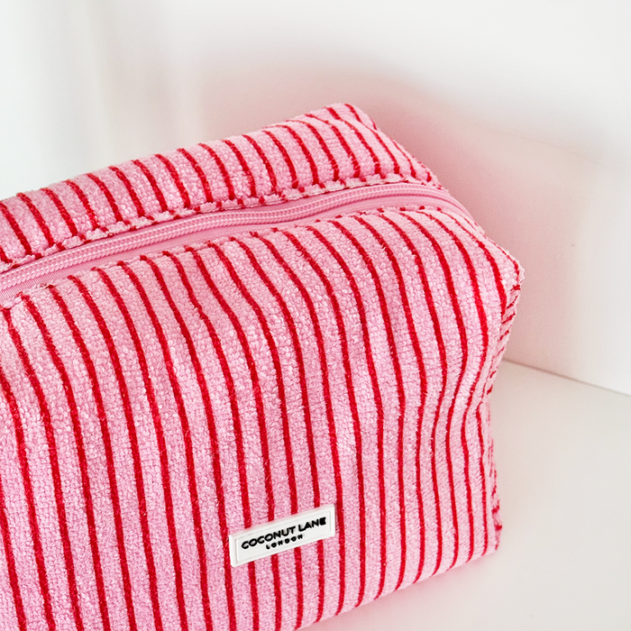 Pink and red striped towel makeup bag with a zipper and a small front label.