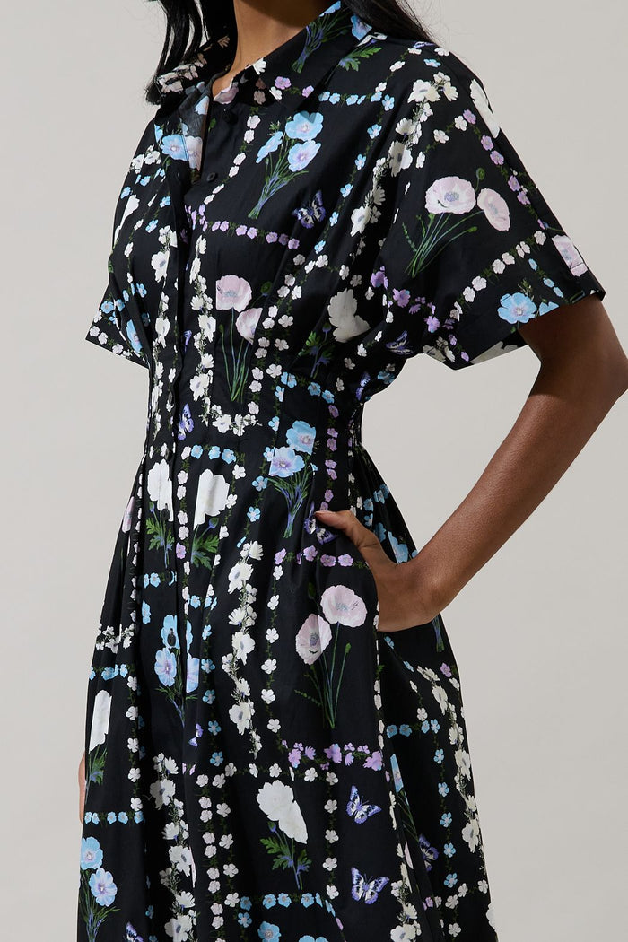 Close-up of black floral cotton midi dress showing collar, button placket, short sleeve and side pocket